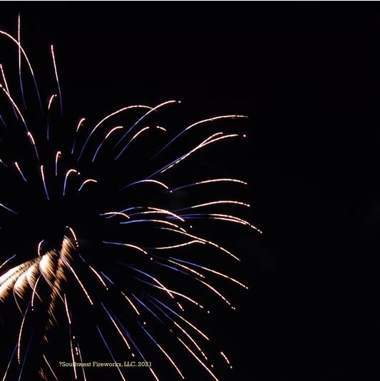 Gold and blue chrysanthemum shell break in close detail Close-up of a large gold and blue chrysanthemum fireworks shell breaking across the night sky with long trailing sparks